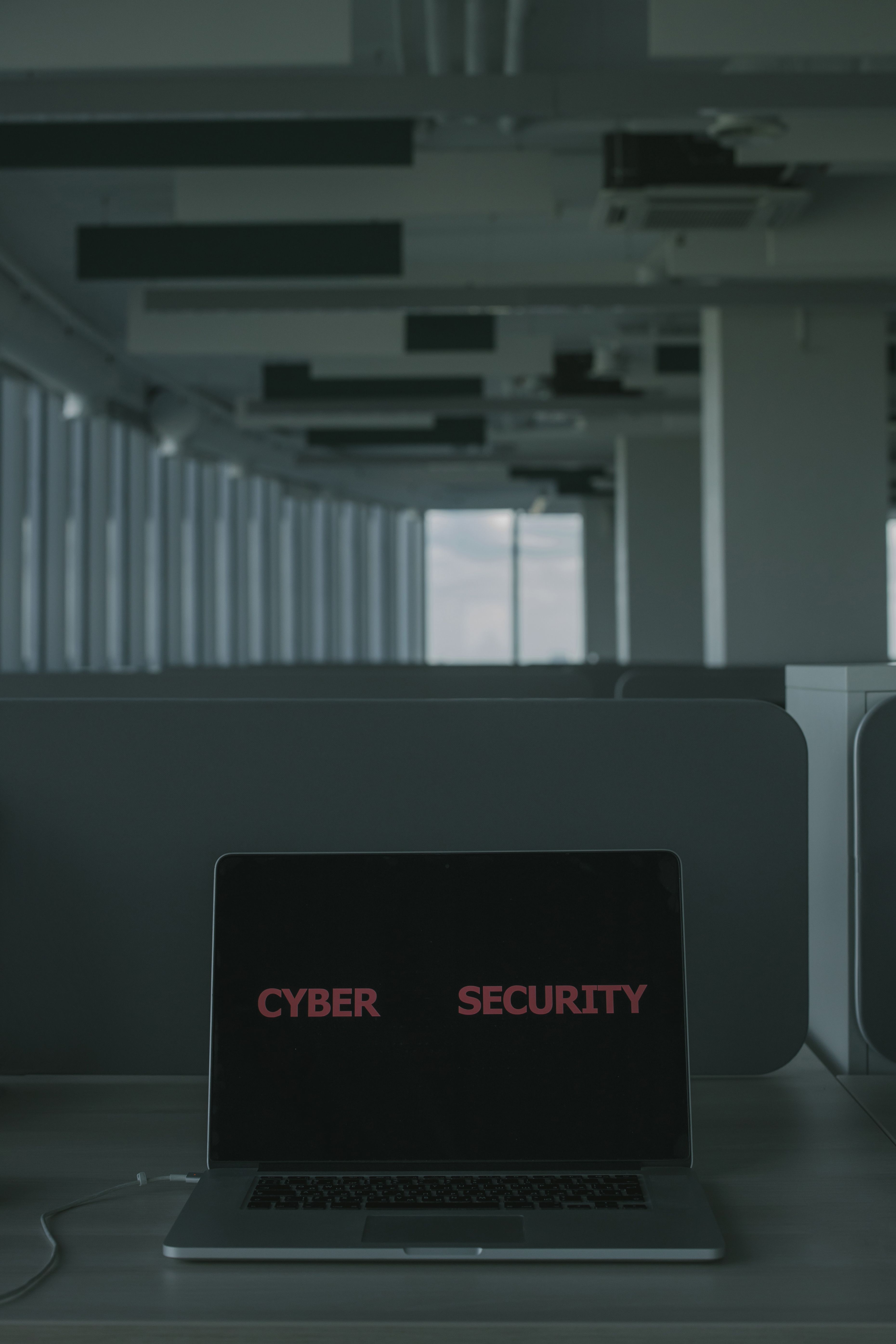 Laptop displaying cyber security text in an office